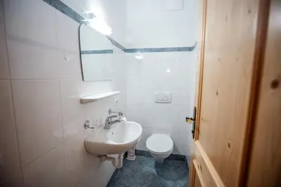 a white bathroom with a sink and a toilet at Grossberghütte in Maranza