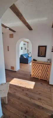 a room with a bed and a television and a wooden floor at La Dimora del Sole in Carano