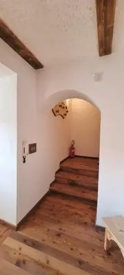 a hallway with an archway in a room with wooden floors at La Dimora del Sole in Carano
