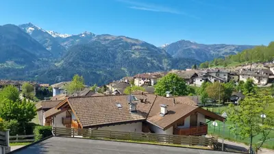 a house with a roof with mountains in the background at La Dimora del Sole in Carano