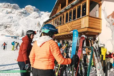 a group of people standing in front of a ski lodge at Rifugio Bec de Roces in Pallua