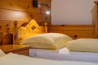 a bedroom with a bed with a wooden head board at Rifugio Bec de Roces in Pallua