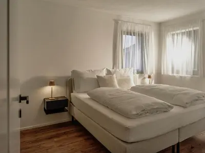 a white bed in a room with a window at Dolomina in Funes