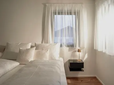 a white bedroom with a bed and a window at Dolomina in Funes