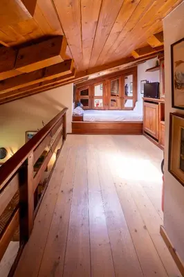 a large room with wooden floors and a wooden ceiling at Spacious Alpine Loft with Stunning Antelao Views in San Vito di Cadore