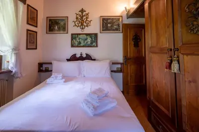 a bedroom with a white bed with towels on it at Spacious Alpine Loft with Stunning Antelao Views in San Vito di Cadore