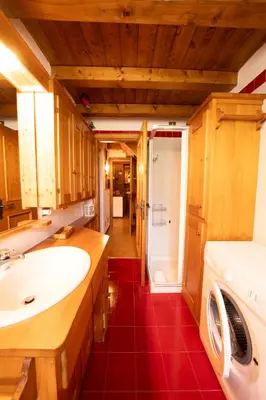 a bathroom with a sink and a washing machine at Spacious Alpine Loft with Stunning Antelao Views in San Vito di Cadore