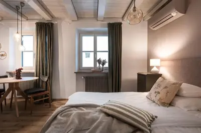 a bathroom with a sink and a bathroom with a bed at Bogen bistro & apartments in Bolzano