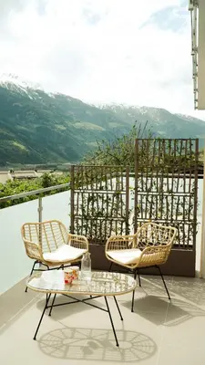 two chairs and a table on a balcony with a view at Texlhof - Stella Alpina in Parcines