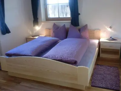a bedroom with a bed with purple pillows and a window at Winterklaubhof in Siusi