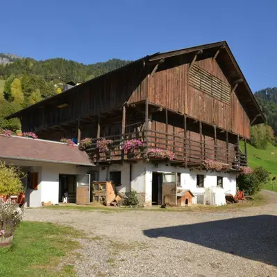 a large wooden barn with flowers on it at Winterklaubhof in Siusi
