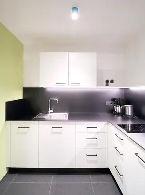a kitchen with white cabinets and a sink at Apartment Luis 1 - Alpstay in Naturno