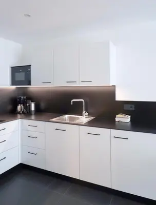 a kitchen with white cabinets and a sink at Apartment Luis 2 - Alpstay in Naturno