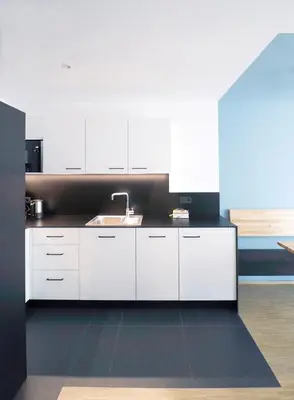 a kitchen with white cabinets and a sink at Apartment Luis 2 - Alpstay in Naturno