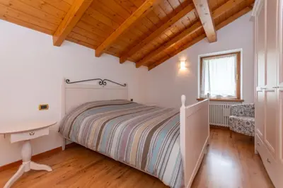 a bedroom with a bed and a desk at La Casa di Elvira-Mansarda in Alleghe