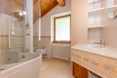 a bathroom with a tub and a sink and a shower at La Casa di Elvira-Mansarda in Alleghe