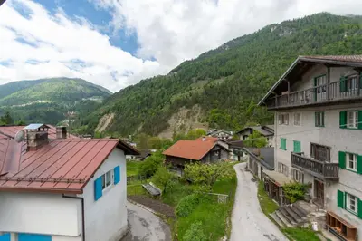 a village in the mountains with houses and a road at La Casa di Elvira-Mansarda in Alleghe