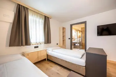 a kitchen and living room with a table and a couch at Eden Dolomites in Selva di Val Gardena