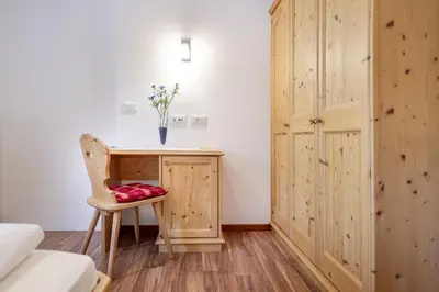 a room with a desk with a chair and a cabinet at Apartments Ciancel Gino in Ortisei