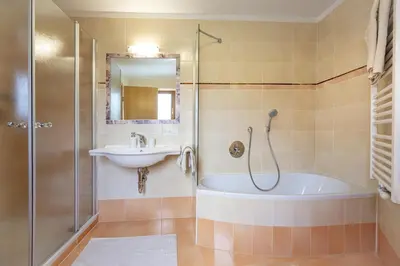 a bathroom with a tub and a sink and a shower at Apartments Ciancel Gino in Ortisei