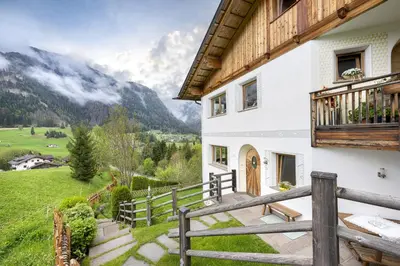 a house in the mountains with a balcony at Apartments Ciancel Gino in Ortisei