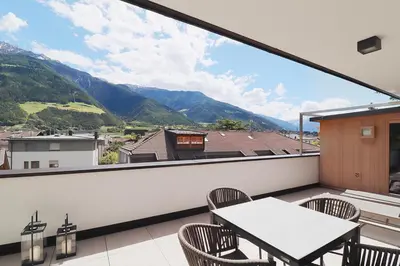 a balcony with a table and chairs and mountains at Apartment Luis 3 - Alpstay in Naturno