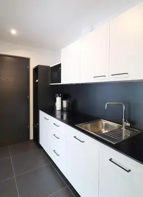 a kitchen with white cabinets and a sink at Apartment Luis 3 - Alpstay in Naturno