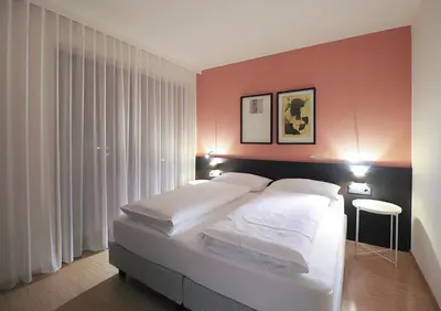 a bedroom with a large white bed with pink walls at Apartment Luis 3 - Alpstay in Naturno