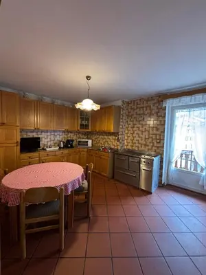 a kitchen with a table with a pink table cloth on it at Appartamento di Nina in Moena