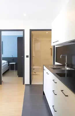 a kitchen with white cabinets and a sink and a bathroom at Apartment Luis 4 - Alpstay in Naturno