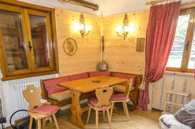 a dining room with a wooden table and chairs at Casa Salvaniera in San Vito di Cadore