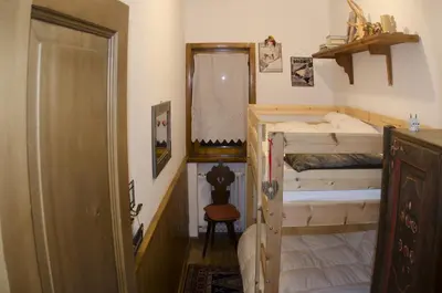 a small bedroom with a bunk bed and a doorway at Casa Salvaniera in San Vito di Cadore