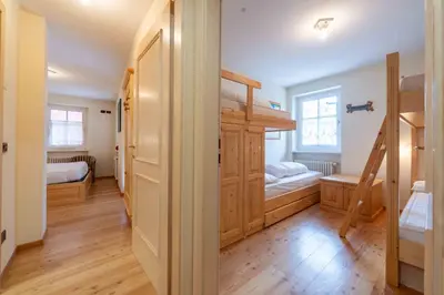 a room with two bunk beds and a hallway at Cesa Masè in Pozza di Fassa