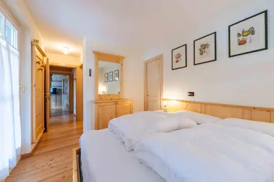 a bedroom with two white beds in a room at Cesa Masè in Pozza di Fassa