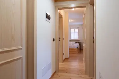 a hallway with a door leading to a bedroom at Cesa Masè in Pozza di Fassa
