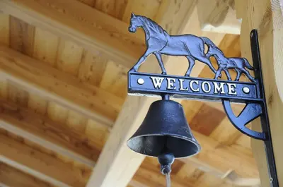 a welcome sign with a horse on a bell at Horse House in Romallo