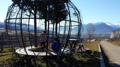 a young boy sitting in a bird cage at Horse House in Romallo