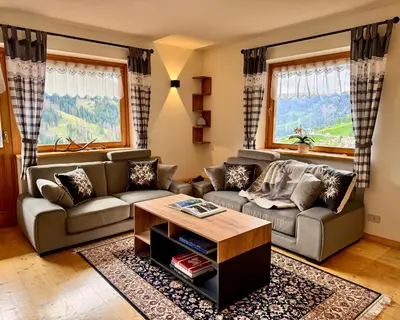 a living room with a couch and a table at Antler Apartment in Santa Fosca