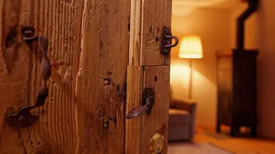 a wooden door with a handle in a room at Silentium Dolomites Chalet in Monguelfo