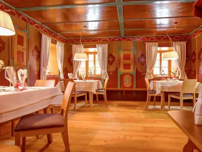 a dining room with white tables and chairs at Silentium Dolomites Chalet in Monguelfo
