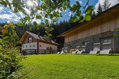 a group of chairs in a yard next to a building at Silentium Dolomites Chalet in Monguelfo