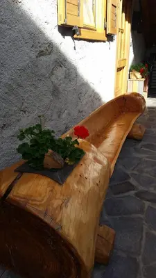 a wooden bench with flowers on top of it at Casa Danoli in Canale San Bovo