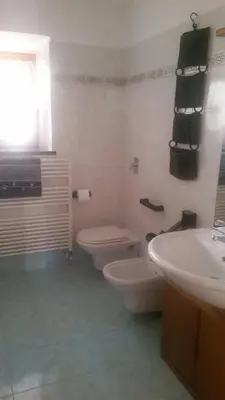 a white bathroom with a toilet and a sink at Casa Danoli in Canale San Bovo