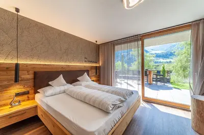 a bedroom with a large bed and a large window at Residence Chalet Riad in Saltusio