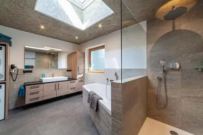 a bathroom with a sink and a shower with a skylight at Residence Chalet Riad in Saltusio
