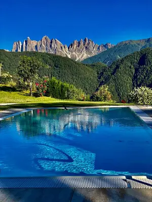 a large pool of water with mountains in the background at Oberprantschöllhof - Horse Mountain Stable in Bressanone