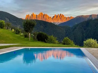 a swimming pool with mountains in the background at Oberprantschöllhof - Horse Mountain Stable in Bressanone
