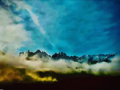 a view of a mountain range in the clouds at Oberprantschöllhof - Horse Mountain Stable in Bressanone