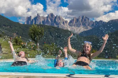 three women are playing in a swimming pool at Oberprantschöllhof - Horse Mountain Stable in Bressanone