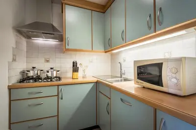 a kitchen with a microwave oven and a sink at Ciasa Odlina in La Villa